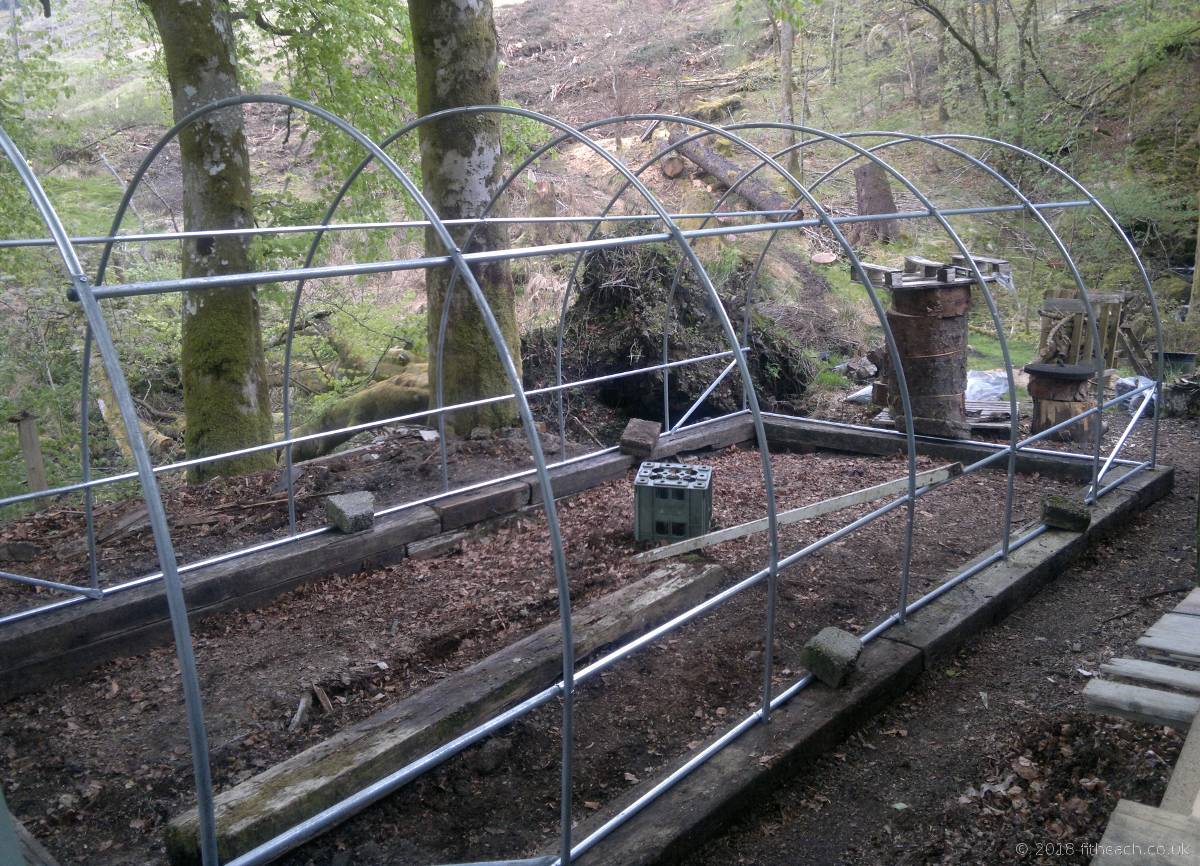 The polytunnel frame sitting on a base of railway sleepers