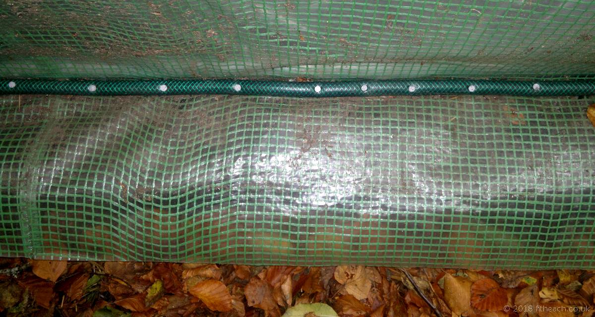 Section of the polytunnel skirt, nailed to the sleepers with a hosepipe for cushioning.