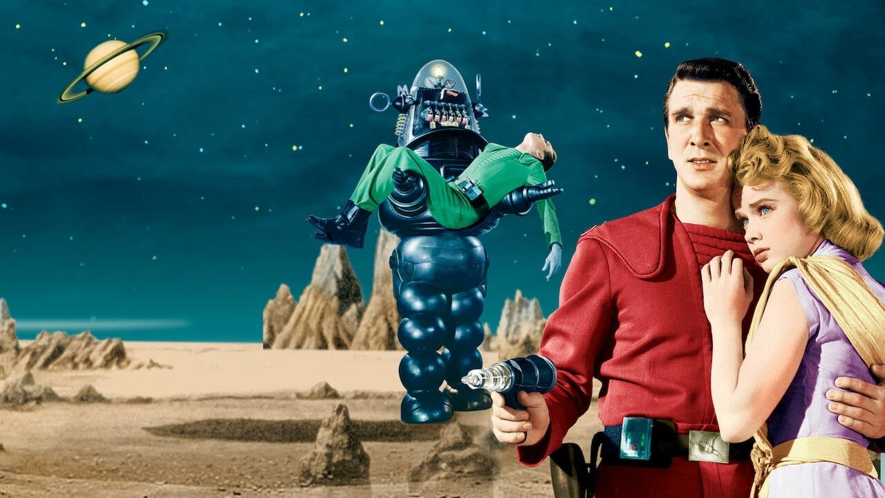 Poster scene showing the two main stars embracing, and Robby the Robot in the background (carrying a limp body).