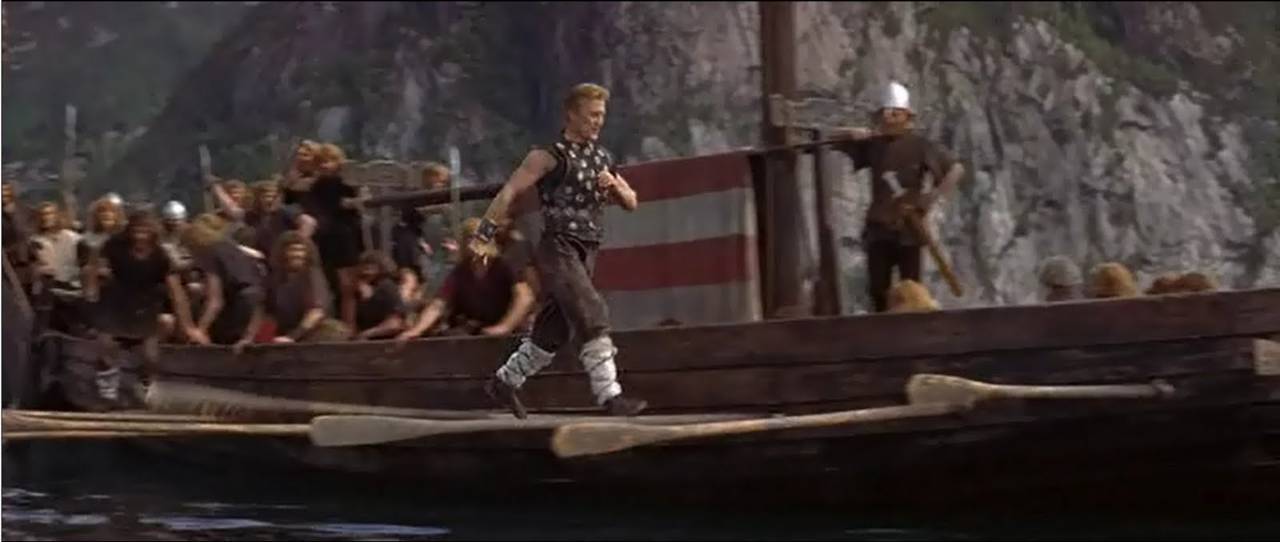 Scene from the movie "The Vikings". Kirk Douglas walks along the side of the longship, using the oars as steps.